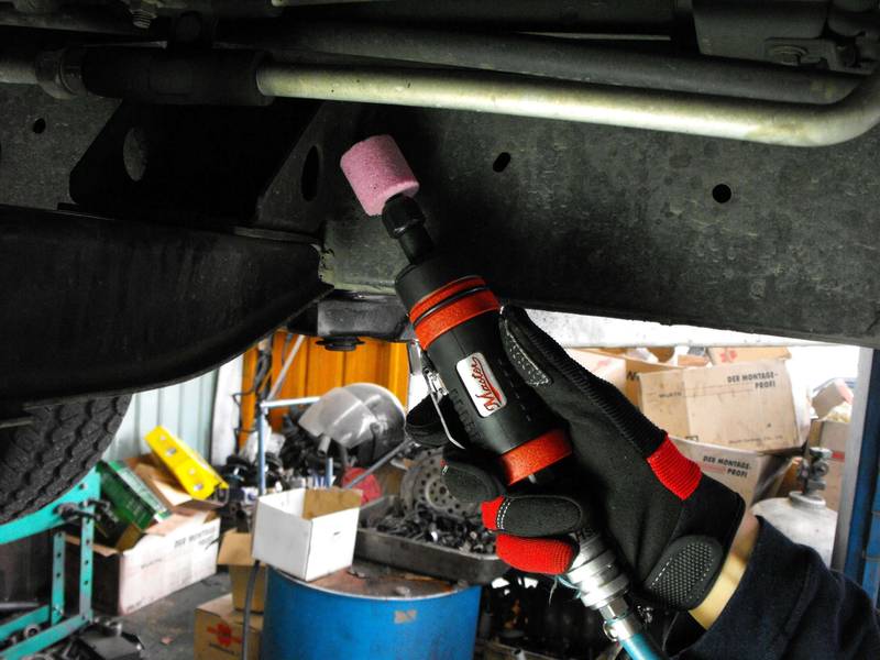 a man working on a car under a vehicle