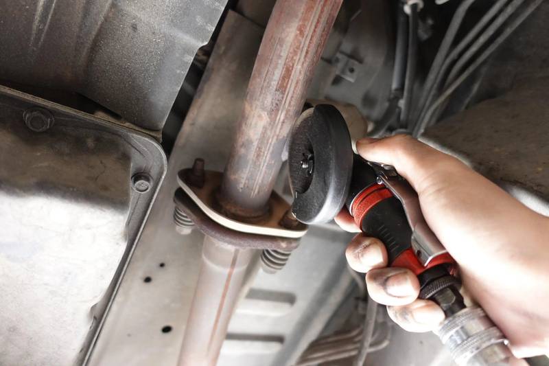 a person is working on a vehicle with a wrench